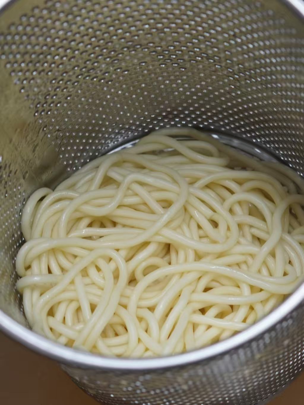 煮好的碱水面盛在漏勺中